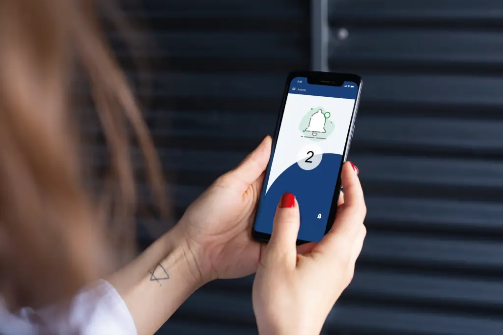 Zdravotní sestra používá mobilní aplikaci pro tísňové volání a lokalizaci